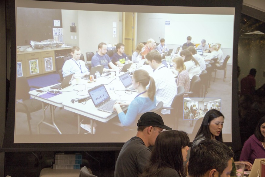 A photo of the Amazon Music team working on laptops displayed on the projector.